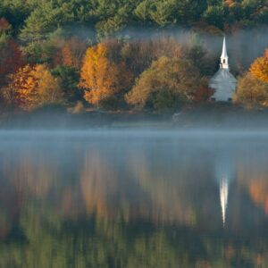 white chapel beside body of water