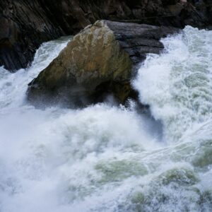 a large rock sticking out of the middle of a river